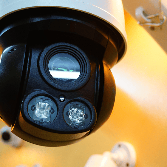 Überkopfansicht einer Überwachungskamera mit zwei Infrarot-LEDs und einem Objektiv in einem hellen Umfeld.